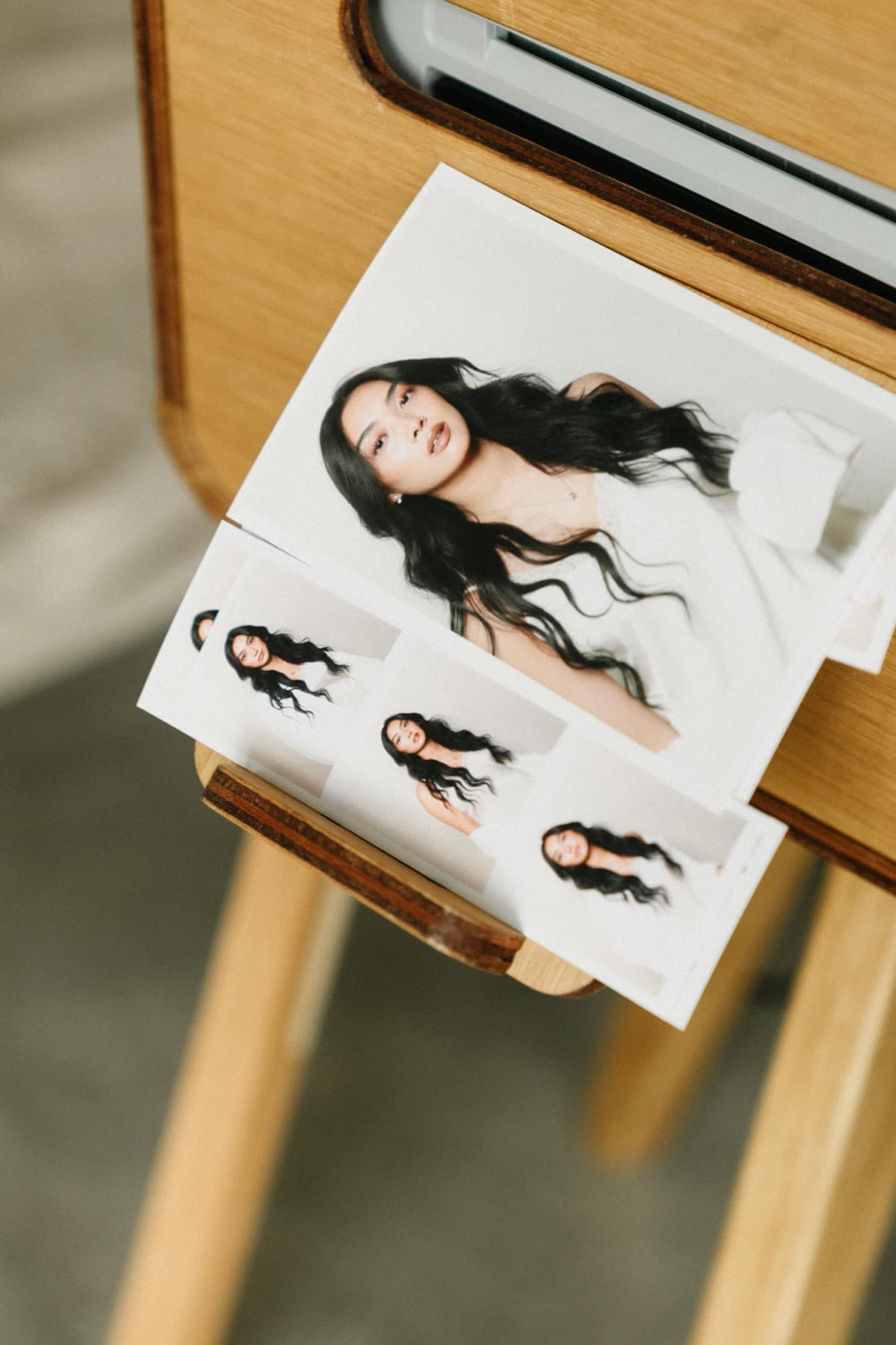 Freshly printed portraits and a photo strip emerging from the MEMORI booth printer.